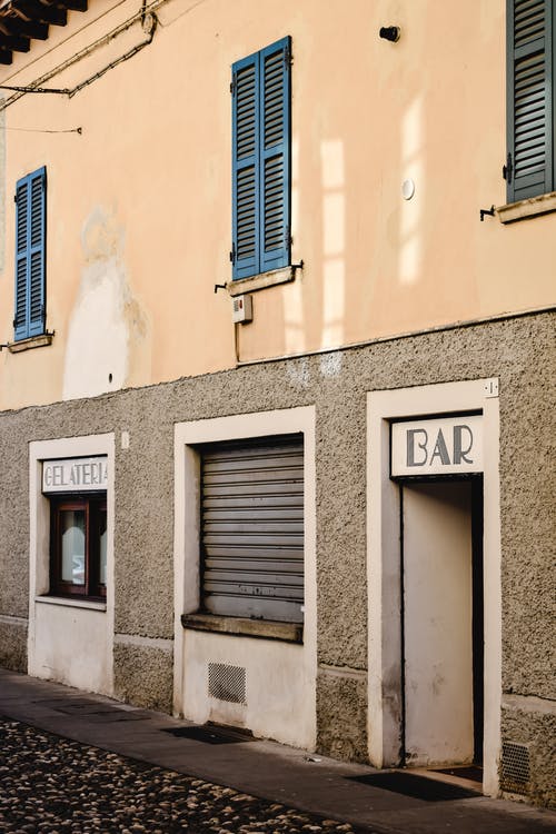 在米色的混凝土建筑上的蓝色木窗 · 免费素材图片