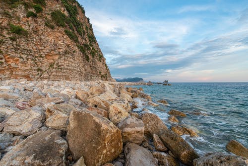 水体附近的棕色多岩石的海岸 · 免费素材图片