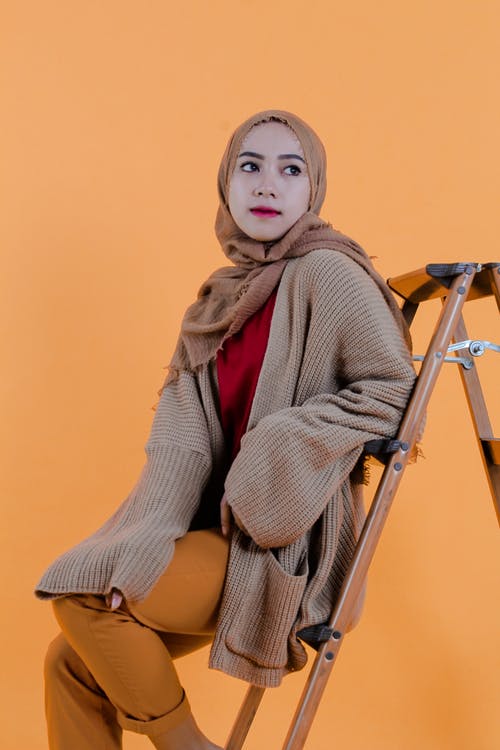 棕色和白色的条纹的长袖衬衫，坐在棕色的椅子上的女人 · 免费素材图片