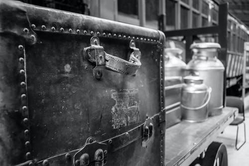 拖车上有牛奶搅动的旅行箱的灰度摄影 · 免费素材图片