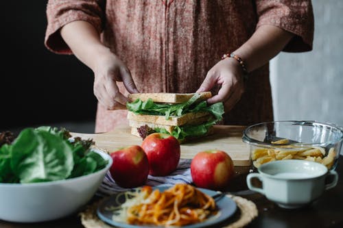 裁剪女人烹饪在木板上的健康三明治 · 免费素材图片