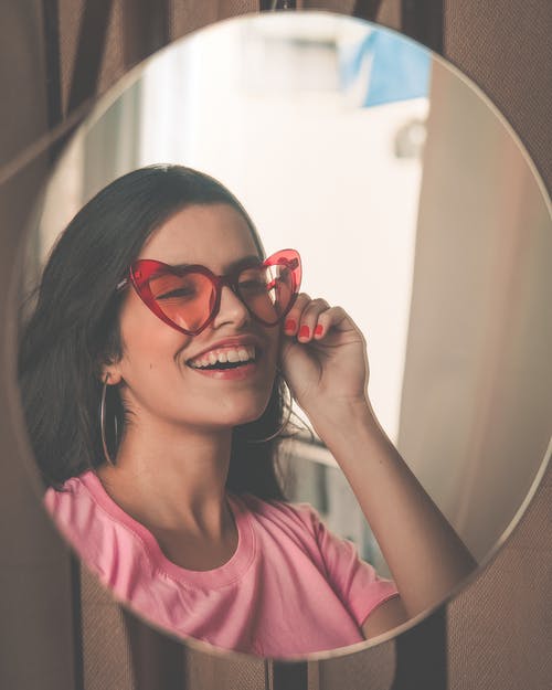 微笑的女士戴着红色太阳镜 · 免费素材图片
