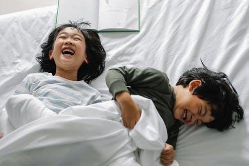 微笑在床上的亚洲孩子 · 免费素材图片