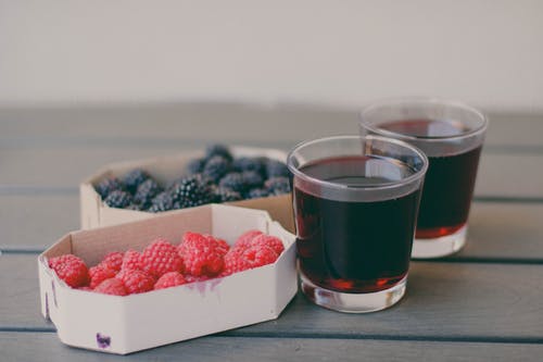 两个装有树莓和蓝莓果汁的水杯 · 免费素材图片