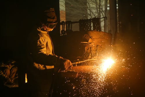 男员工与焊接机一起工作 · 免费素材图片