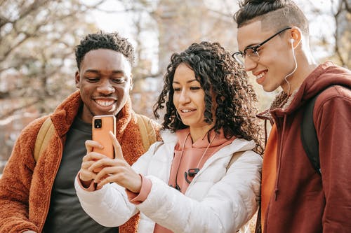 拿着金iphone 6的白色长袖衬衫的女人 · 免费素材图片