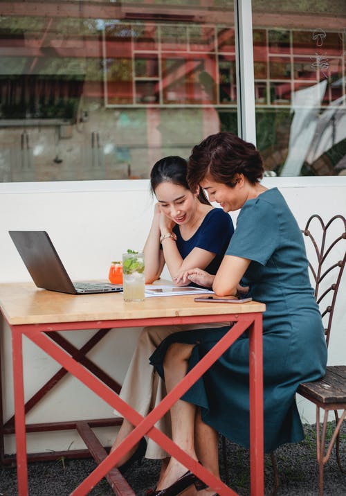 亚洲妇女浏览在咖啡馆的平板电脑 · 免费素材图片