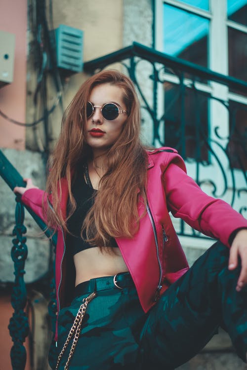 靠在楼梯上的红色皮夹克的女人 · 免费素材图片