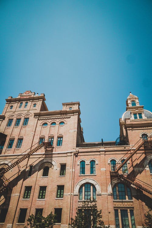 湛蓝的天空下的棕色高层混凝土建筑 · 免费素材图片