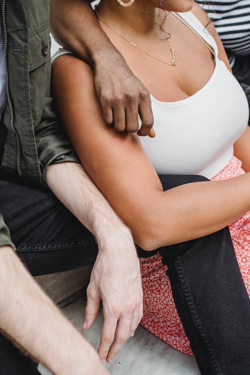 白色背心坐在红色和白色纺织上的女人 · 免费素材图片