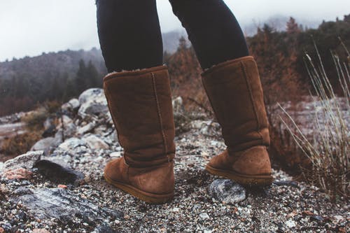 一个穿着棕色的冬季靴子的人的特写摄影 · 免费素材图片