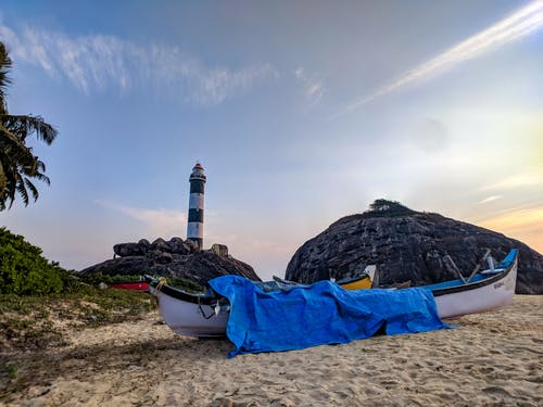 白色独木舟与蓝色的封面，在沙滩上 · 免费素材图片