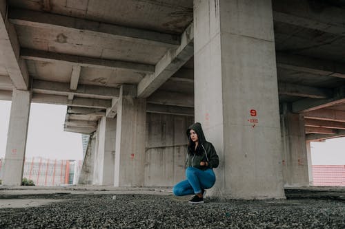 坐在混凝土桥下的女人 · 免费素材图片