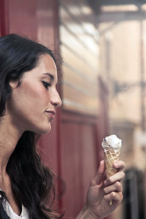 一个拿着冰淇淋的女人的摄影 · 免费素材图片