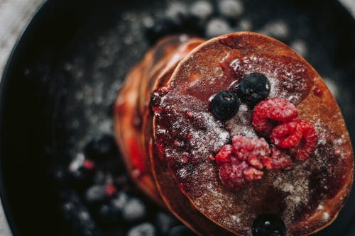覆盆子和蓝莓煎饼的选择性聚焦摄影 · 免费素材图片