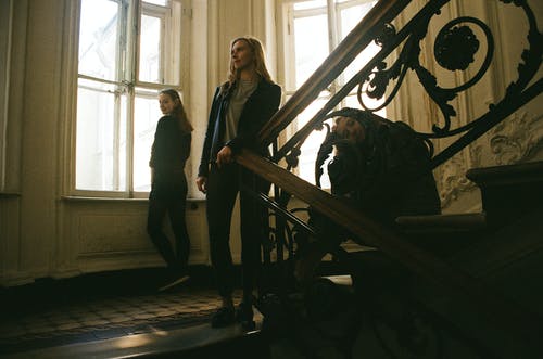 站在楼梯附近坐着的妇女的照片 · 免费素材图片