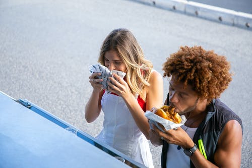 多种族的夫妇在大街上吃垃圾食品 · 免费素材图片