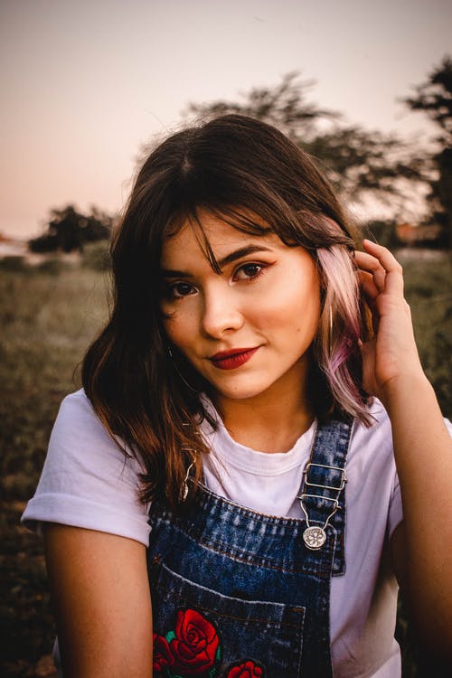 微笑的女人坐在草地上的肖像照片 · 免费素材图片