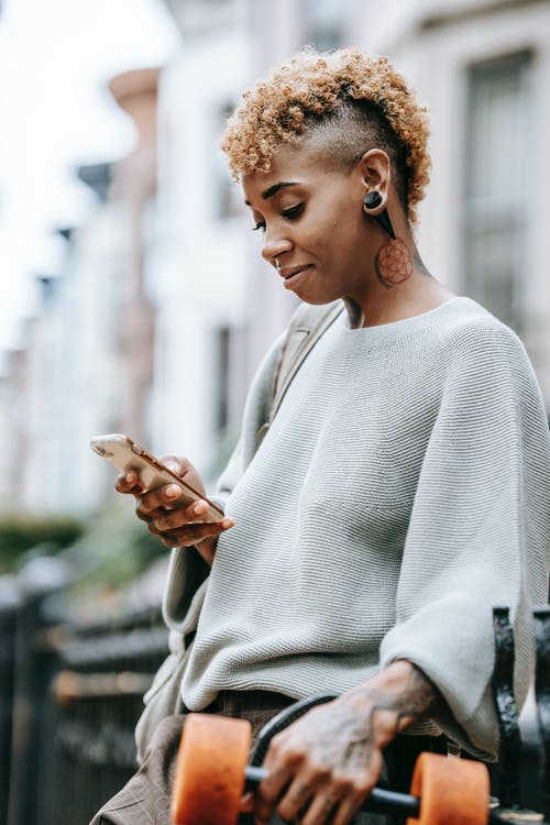 有智能手机的微笑的妇女在街道上 · 免费素材图片