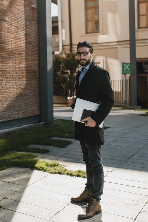 拿着白皮书的黑色西装的男人 · 免费素材图片