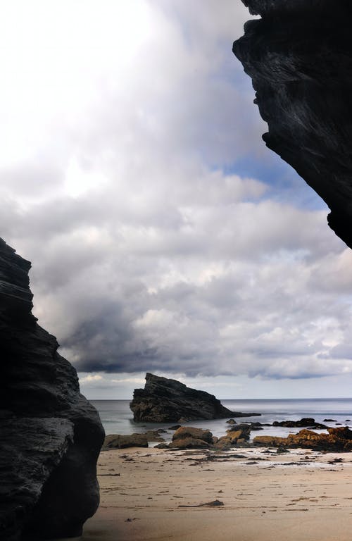 在白云和蓝天下的海岸岩石 · 免费素材图片