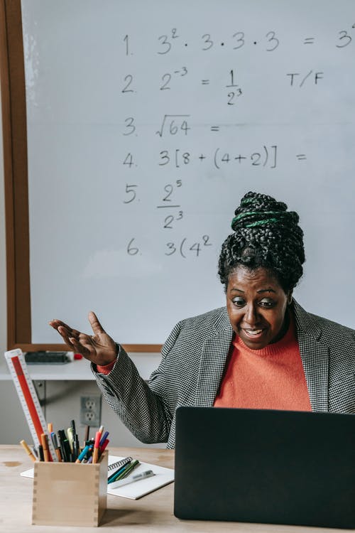 激动的黑人老师用笔记本电脑在线解释课 · 免费素材图片