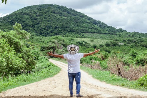 站在土路上的人戴着帽子的照片 · 免费素材图片