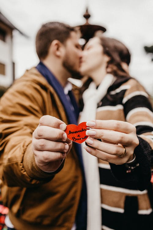 男人和女人抱着心饰品接吻 · 免费素材图片