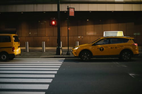 舒适的出租车停在城市街道上的交通信号灯附近 · 免费素材图片