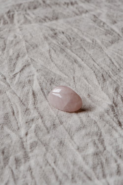 白色纺织上的粉红色石头 · 免费素材图片