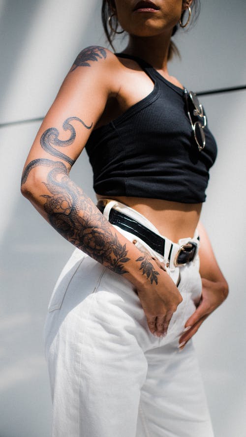 女人穿着黑色作物和白色牛仔裤 · 免费素材图片