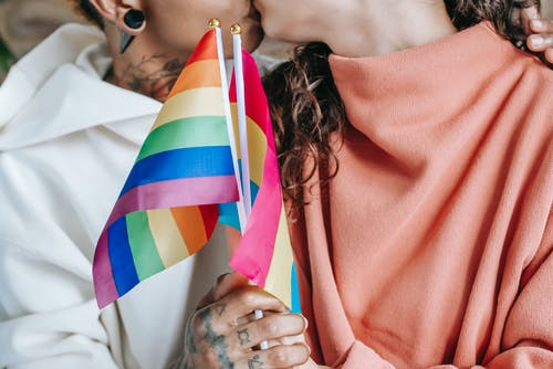 裁剪不露面的女同性恋夫妇亲吻和拥抱lgbt标志 · 免费素材图片