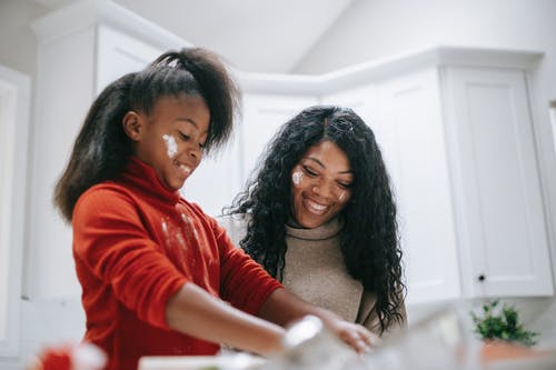 快乐肮脏的黑人女孩，与母亲在厨房做饭 · 免费素材图片