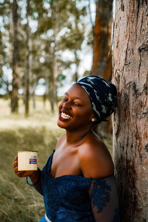 蓝花掉肩顶抱着白色杯子的女人 · 免费素材图片