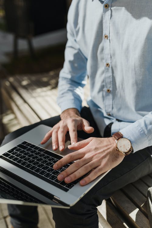 使用macbook Pro的蓝色礼服和黑色裤子的人 · 免费素材图片