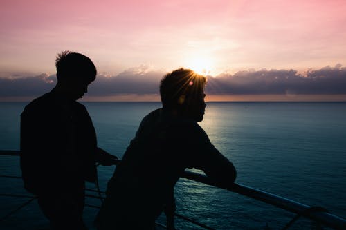 两名男子站在栏杆旁 · 免费素材图片