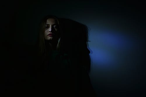 在黑暗的房间里的女人的照片 · 免费素材图片