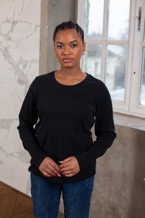 黑色长袖衬衫站在白墙上的女人 · 免费素材图片