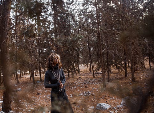 女人穿着长袖的衣服站在树附近 · 免费素材图片