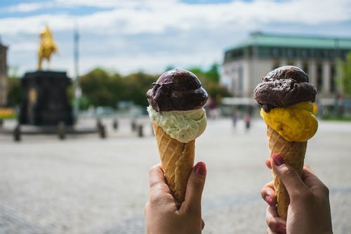 拿着两个冰淇淋的人的摄影 · 免费素材图片