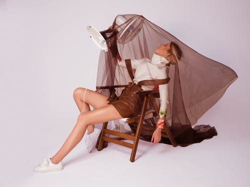 椅子上的时尚女人与风扇 · 免费素材图片