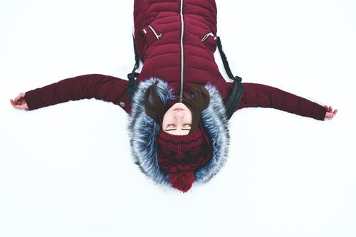 躺在雪地里，张开双臂的女人 · 免费素材图片