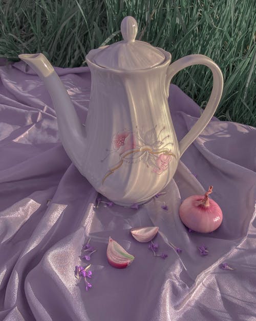 陶瓷茶壶和丝绸上的洋葱 · 免费素材图片