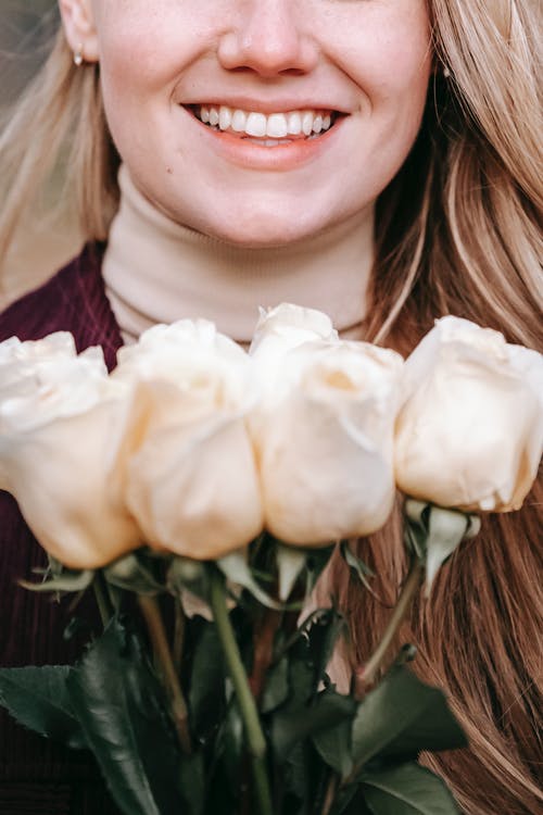 拿着白花的紫色衬衣的妇女 · 免费素材图片