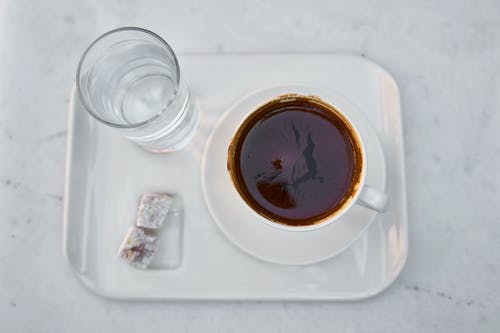 白色陶瓷杯上满满棕色液体的白色茶碟 · 免费素材图片