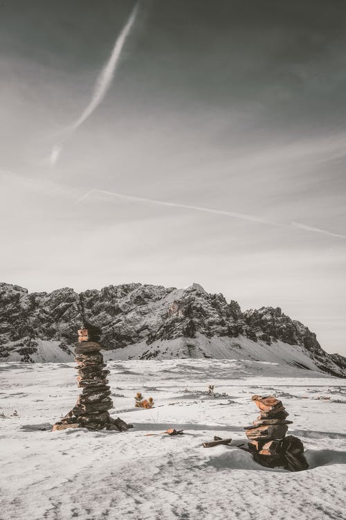 堆石头在积雪覆盖的田野上 · 免费素材图片