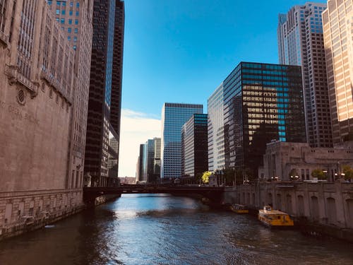 船停靠在高层建筑物附近 · 免费素材图片