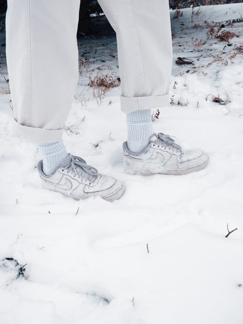 白裤子和耐克鞋站在雪地上的人 · 免费素材图片