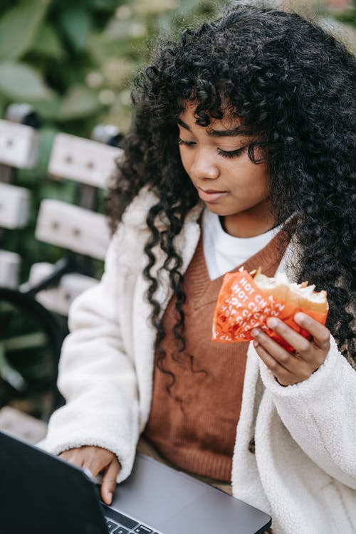 拿着橙色食物的白大褂的女人 · 免费素材图片