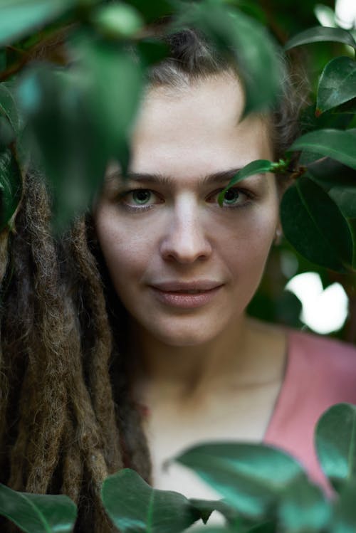 女人在植物附近的选择性焦点照片 · 免费素材图片